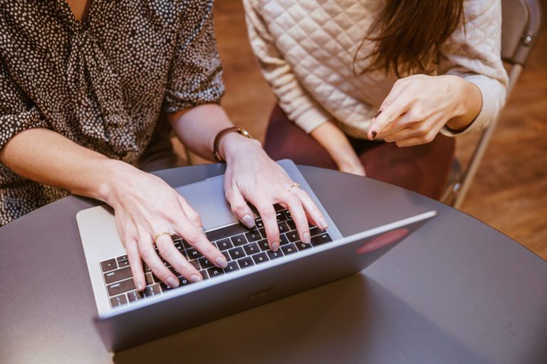 Photo of women hands typing code on computer